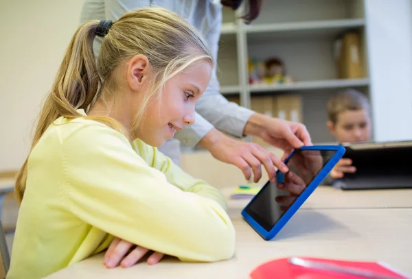 Little girl with teacher and tablet pc at school — Stock Photo, Image