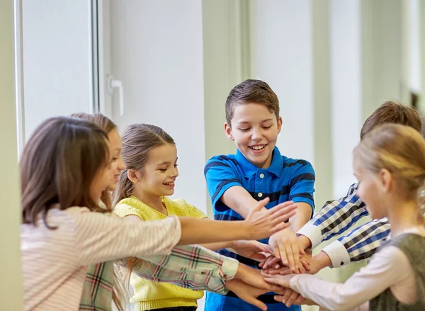 Grupo de crianças da escola sorrindo colocando as mãos no topo — Fotografia de Stock