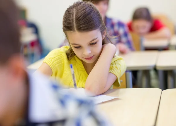 Group of school kids writing test in classroom — Stock Photo, Image