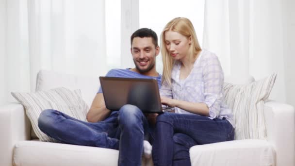 Pareja sonriente con ordenador portátil en casa — Vídeos de Stock