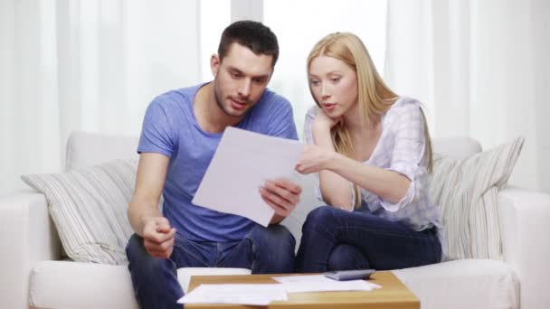 Couple occupé avec papiers et calculatrice à la maison — Video