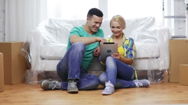 Smiling couple with tablet pc in new home — Stock Video