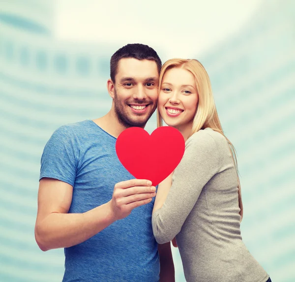 Sorridente coppia tenendo grande cuore rosso — Foto Stock