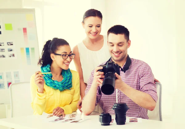 Equipo sonriente con cámara fotográfica trabajando en la oficina —  Fotos de Stock