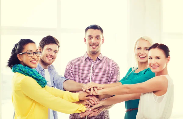 Team with hands on top of each other in office — Stock Photo, Image