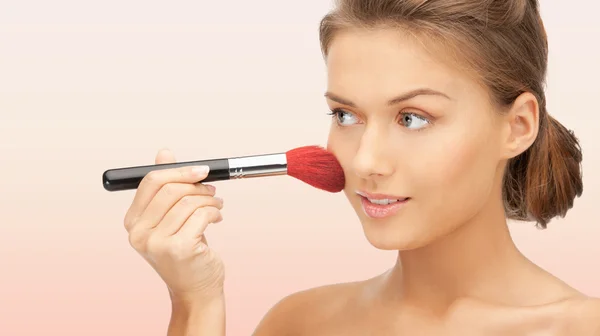 Schöne lächelnde Frau mit Make-up Pinsel — Stockfoto