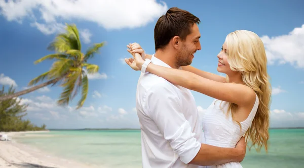 Feliz pareja abrazándose sobre playa fondo —  Fotos de Stock