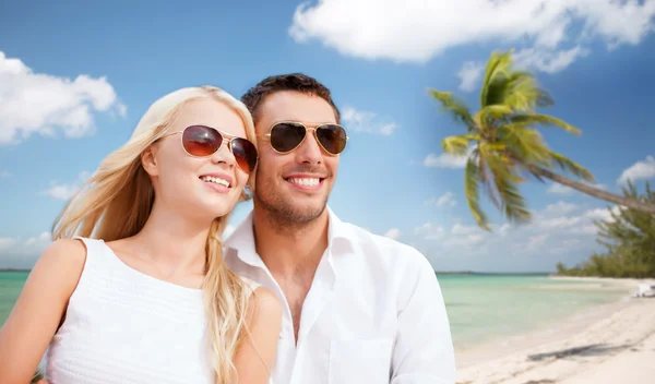 Paar in tinten over tropisch strand achtergrond — Stockfoto