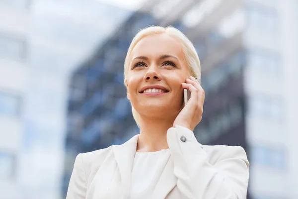 Femme d'affaires souriante avec smartphone en plein air — Photo