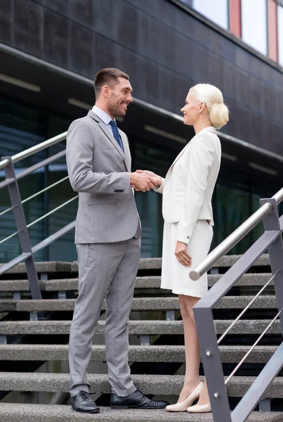 Smiling businessmen shaking hands on street — Stock Photo, Image