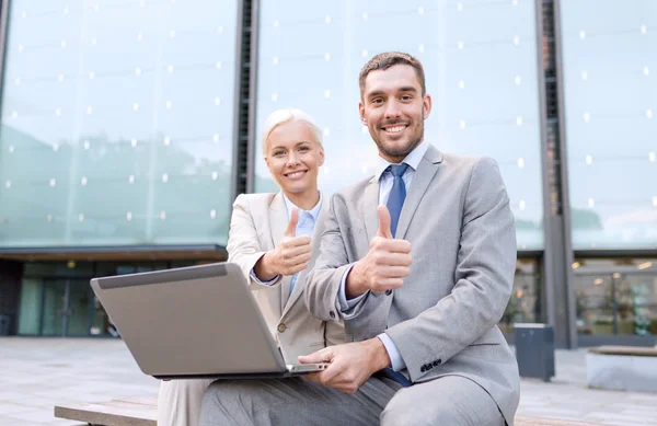 Empresários sorridentes com laptop ao ar livre — Fotografia de Stock