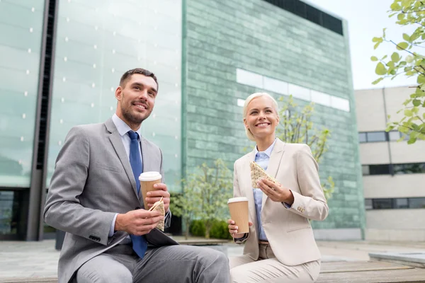 Glimlachende zakenmensen met papier cups buitenshuis — Stockfoto