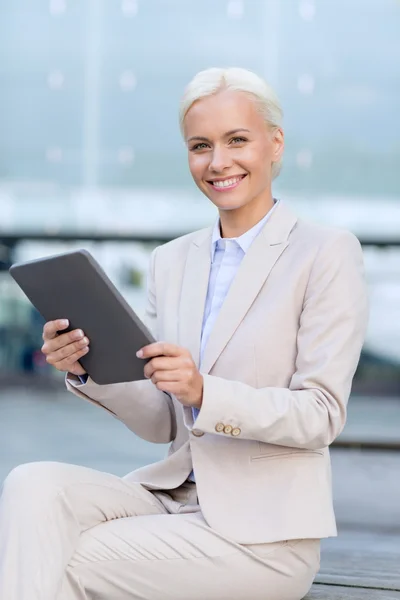 Uśmiechnięta kobieta z komputera typu tablet na zewnątrz — Zdjęcie stockowe