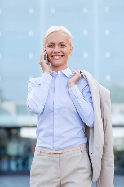 Mujer de negocios sonriente con teléfono inteligente al aire libre — Foto de Stock