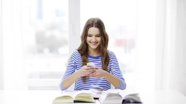 Lachende student meisje met smartphone en boeken — Stockvideo