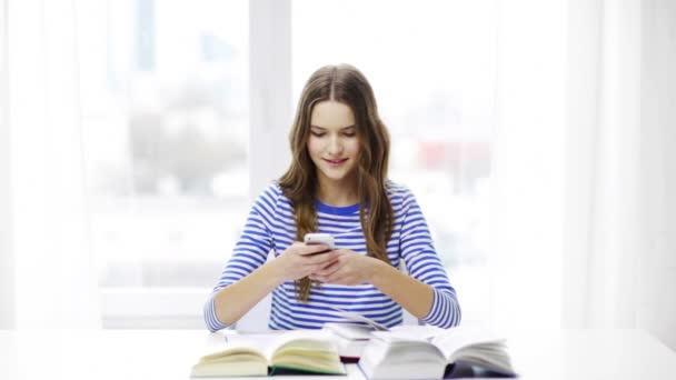 Lachende student meisje met smartphone en boeken — Stockvideo