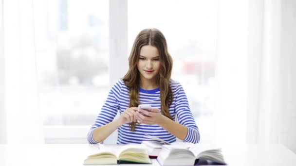 Menina estudante sorridente com smartphone e livros — Vídeo de Stock