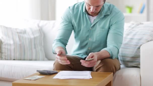Homem contando dinheiro e fazendo anotações em casa — Vídeo de Stock
