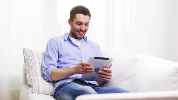 Uomo sorridente che lavora con tablet pc a casa — Video Stock