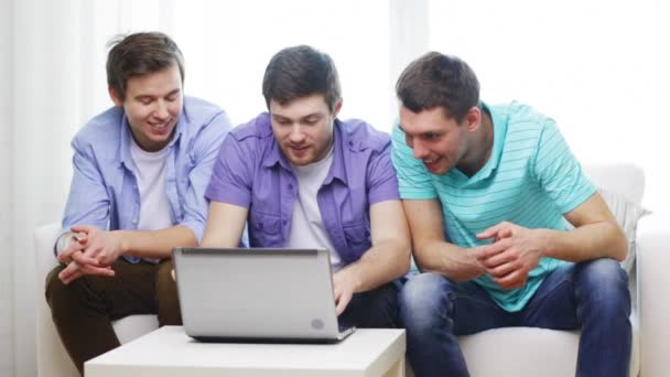 Amigos sorridentes com computador portátil em casa — Vídeo de Stock