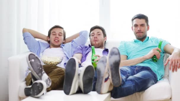 Amis masculins avec bière regarder la télévision à la maison — Video