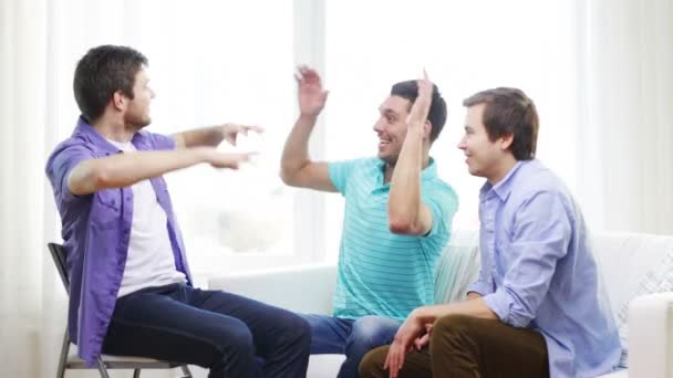 Sonrientes amigos masculinos dando cinco en casa — Vídeos de Stock