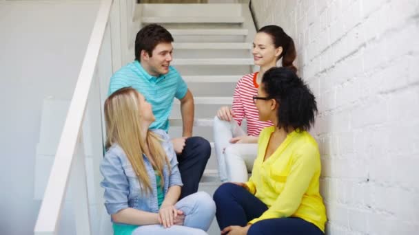 Lächelnde Studenten, die auf Treppen sitzen und reden — Stockvideo