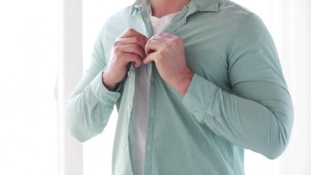 Close-up van de mens buttoning zijn shirt thuis — Stockvideo