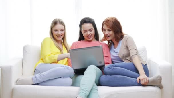 Tres niñas adolescentes sonrientes con ordenador portátil en casa — Vídeos de Stock