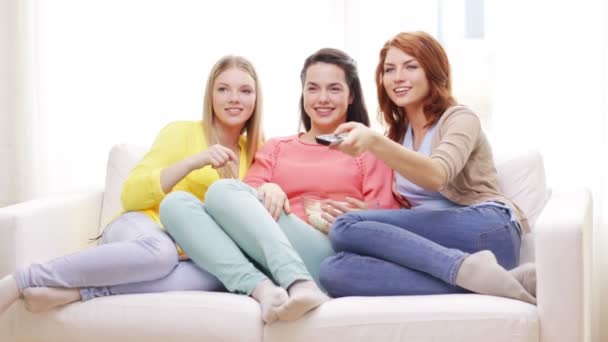 Tři usmívající se dospívající dívky, sledovat tv doma — Stock video