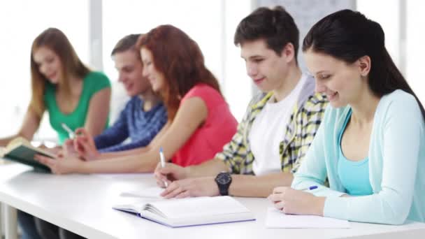 Estudiantes con libros de texto y libros en la escuela — Vídeos de Stock