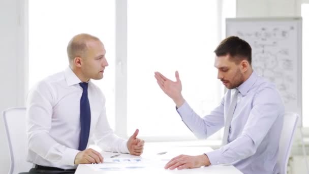 Two serious businessmen with charts in office — Stock Video