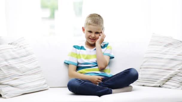 Colegial sonriente con smartphone en casa — Vídeos de Stock