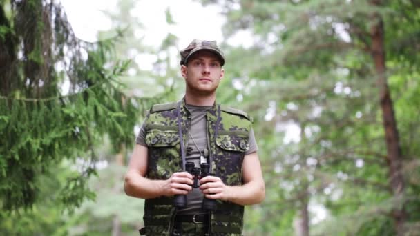 Joven soldado o cazador con binocular en el bosque — Vídeo de stock