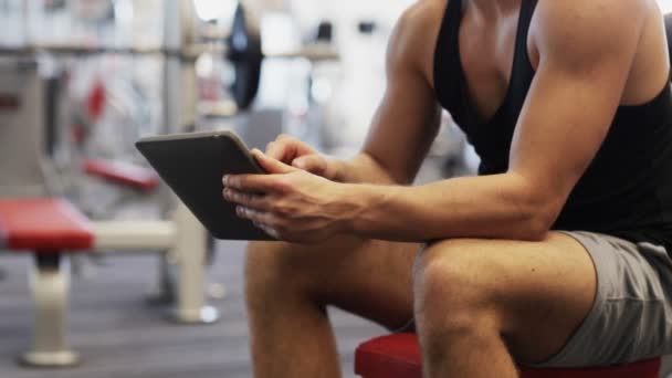 Young man with tablet pc computer in gym — Stock Video