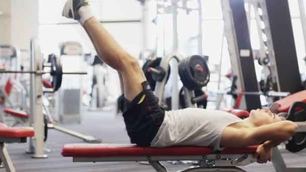 Joven con mancuerna en el gimnasio — Vídeo de stock