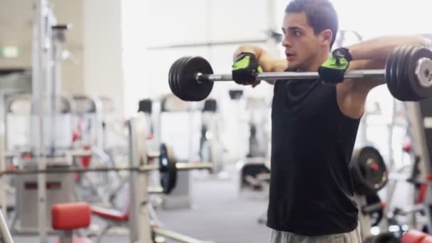 Joven con mancuerna en el gimnasio — Vídeos de Stock