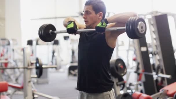 Jeune homme avec haltère en salle de gym — Video