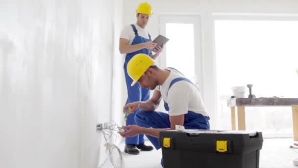 Builders with tablet pc and equipment indoors — Stock Video