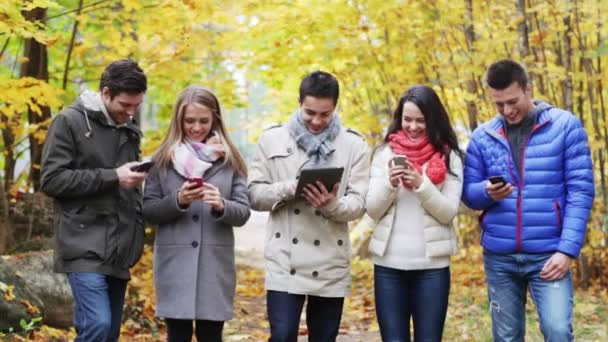 Amigos sorridentes com smartphones e tablet pc — Vídeo de Stock