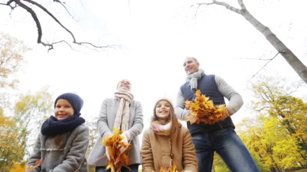 Gelukkige familie spelen met najaar verlaat in park — Stockvideo