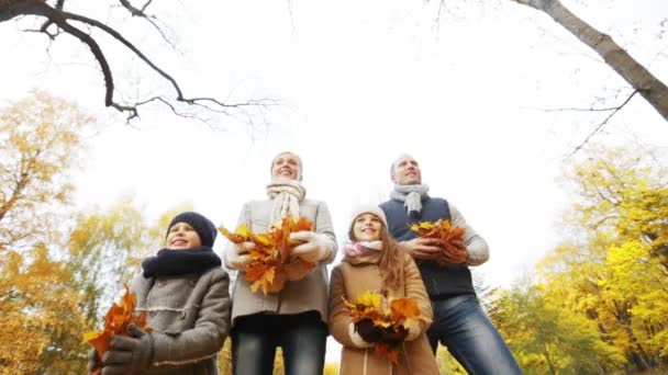 Gelukkige familie spelen met najaar verlaat in park — Stockvideo