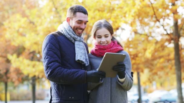 Sonriente pareja con tableta PC en el parque de otoño — Vídeos de Stock