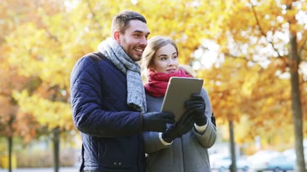 Lachende paar met de tablet pc in de herfst park — Stockvideo