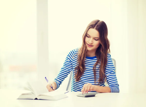 Student tjej med bok, kalkylator och bärbara — Stockfoto