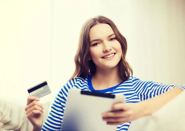 Улыбающаяся девушка с планшетным ПК и кредитной картой — стоковое фото