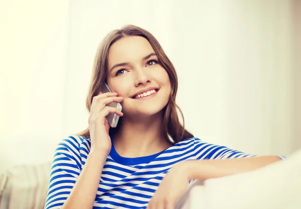 Smiling teenage girl with smartphone at home — Stock Photo, Image