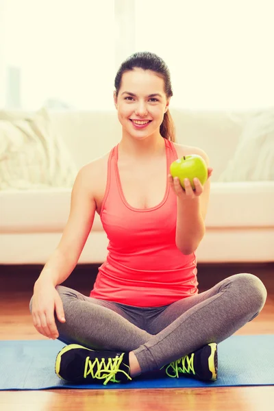 Adolescente souriante avec pomme verte à la maison — Photo