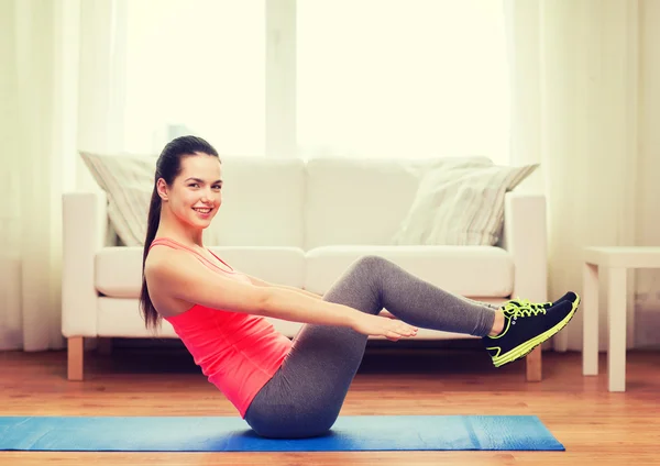 Souriante fille faire de l'exercice sur le sol à la maison — Photo