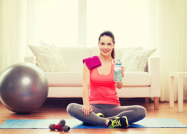 Souriante fille avec bouteille d'eau après l'exercice — Photo